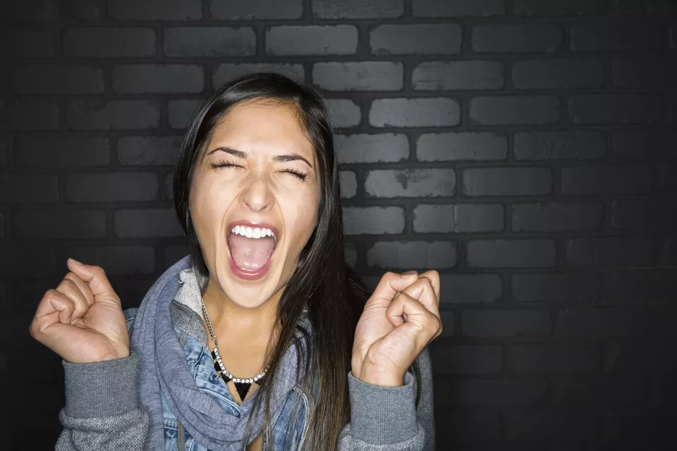 Portrait of enthusiastic brunette woman screaming